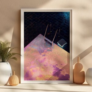 May include: A framed abstract art print with a pink, yellow, and purple color scheme. The print features a textured surface and a dark blue background.