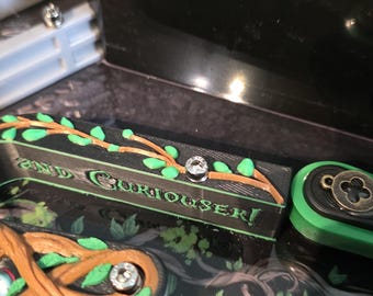 Mejora tu máquina de pinball de Alicia en el País de las Maravillas con rieles de drenaje personalizados.