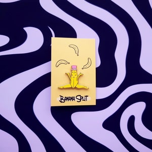 May include: A yellow banana-shaped pin with a pink hat and the text "Banana Split" on a yellow background. The pin is surrounded by four yellow bananas.