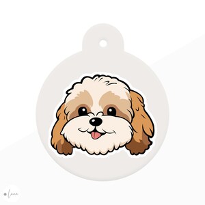 May include: A round, light gray pet tag featuring a cartoon illustration of a Shih Tzu dog. The dog has a white and brown coat, black eyes, and a pink tongue sticking out. The tag has a hole at the top for attachment.