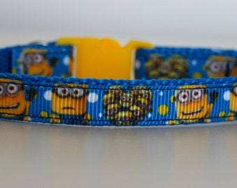 May include: A blue and yellow cat collar with a repeating pattern of Minions. The collar has a yellow plastic buckle.
