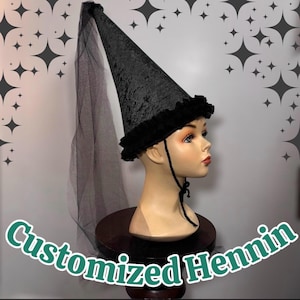 May include: A black velvet hennin hat with a long, sheer veil. The hat has a ruffled trim and a chin strap. The text "Customized Hennin" is displayed in a green font.