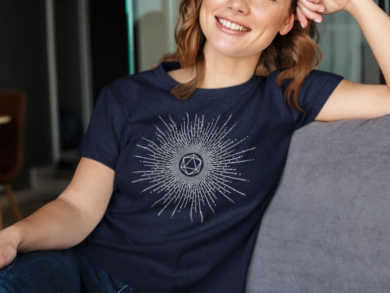 Puede incluir: Una camiseta azul marino con un dise&ntilde;o geom&eacute;trico blanco con un patr&oacute;n de estrella y una forma geom&eacute;trica estilizada en el centro.