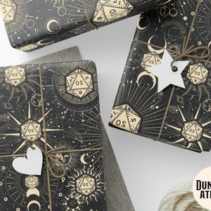 May include: Black and gold wrapping paper with a celestial theme featuring dice, moons, and stars. The text "DUNGEON ATELIER" is printed in the bottom right corner.
