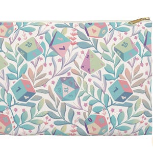 Peut inclure: Une pochette blanche à fermeture éclair avec un motif répété de dés de couleur pastel et de vignes feuillues. Les dés portent des numéros différents, notamment 1, 4, 7, 16, 20 et 8.