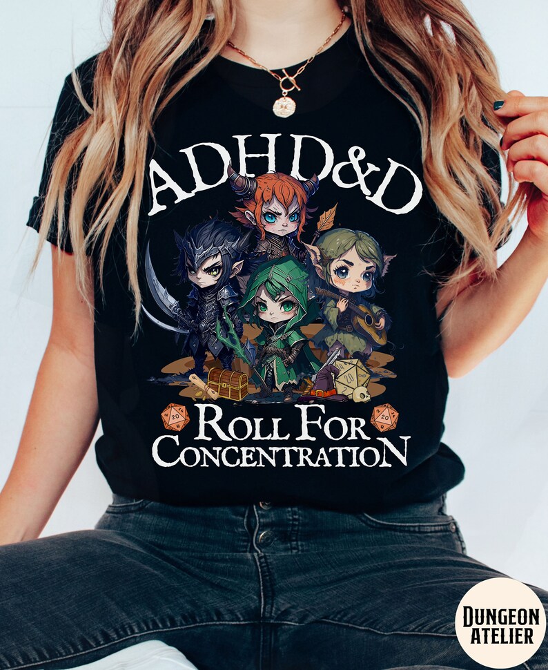 Puede incluir: Camiseta negra con un gr&aacute;fico blanco de cuatro personajes de dibujos animados jugando a Dungeons & Dragons. El texto "ADHD & D Roll For Concentration" est&aacute; impreso en la camiseta.
