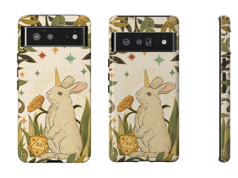 May include: A phone case featuring a whimsical illustration of a rabbit with a unicorn horn, surrounded by flowers and foliage. The design includes a 20-sided die. The case has a cream background with a decorative border.