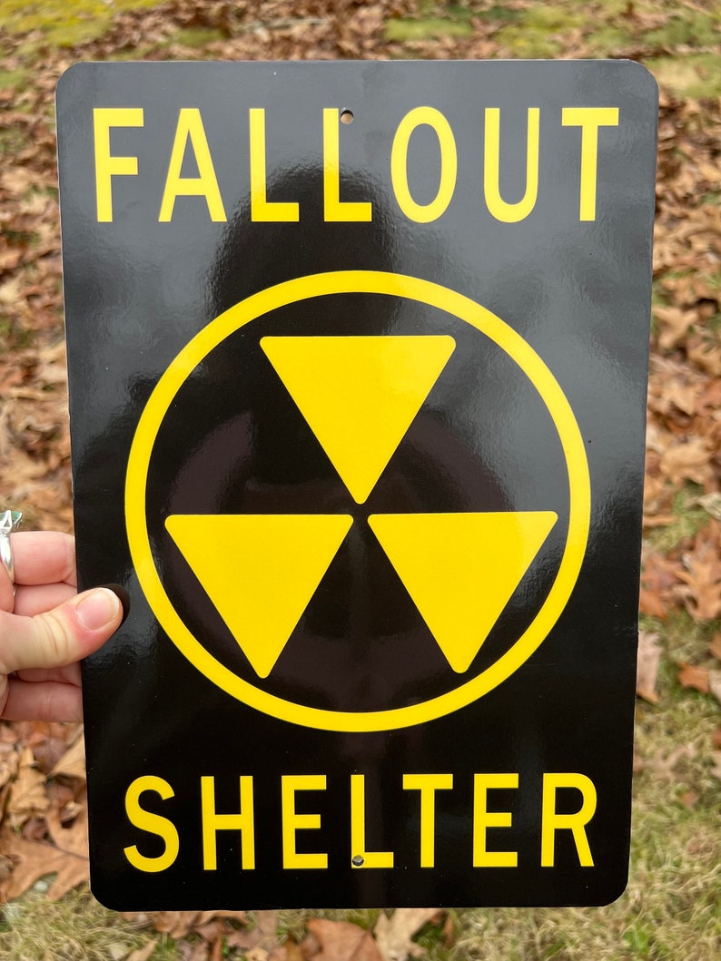 May include: Black and yellow metal sign with the text "Fallout Shelter" and a yellow radiation symbol.