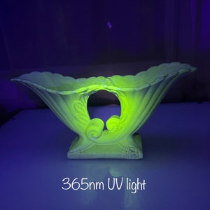 Op de afbeelding: Een gele keramische kom met een decoratief ontwerp, die gloeit onder een 365 nm UV-licht.