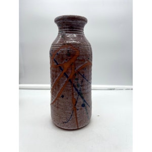 May include: A brown ceramic vase with a white glaze and orange and blue paint splatters.