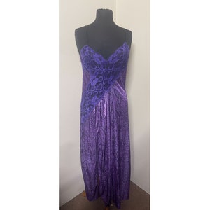 May include: A purple satin slip dress with a black lace overlay. The dress has a V-neckline and thin straps.