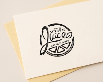 May include: A white card featuring a black circular logo for The Vine Juice Company. The design includes stylised text, a leaf graphic, and a citrus slice motif. The text reads The Vine Juice Company and Always Fresh, Cold-Pressed Juices, Smoothies.