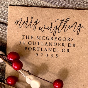 Puede incluir: Un sobre de papel marr&oacute;n con un sello de tinta negra que dice "merry everything." La direcci&oacute;n est&aacute; impresa debajo del saludo: "THE MCGREGORS 54 OUTLANDER DR PORTLAND, OR 97035"