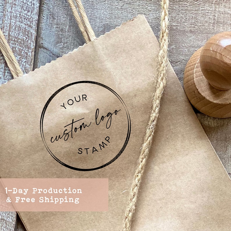 K&ouml;nnte beinhalten: Eine braune Papiert&uuml;te mit einem Seilhenkel. Auf der T&uuml;te befindet sich ein runder schwarz-wei&szlig;er Stempel mit der Aufschrift "Your custom logo stamp".