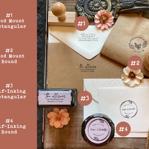 May include: An assortment of self-inking and wood mount rubber stamps in various sizes and shapes. The stamps feature different designs, including names, addresses, and a chicken illustration. The stamps are arranged on a white surface with a brown paper bag and a white envelope.