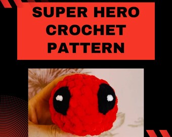 May include: Beginner friendly crochet pattern for a red and black superhero character. The crochet character has a red head with black eyes and a black mouth.