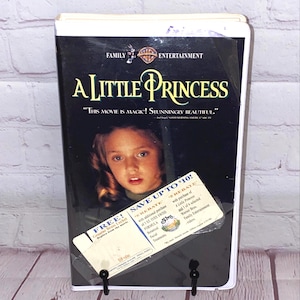 May include: A Little Princess VHS tape. The cover features a young girl with the movie title in gold lettering. The tape has a promotional sticker offering a rebate. The Family Entertainment logo is at the top.