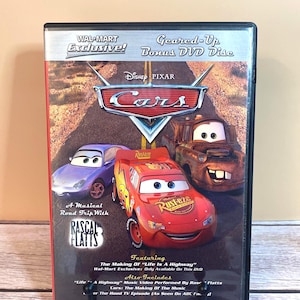 May include: A DVD of the Disney Pixar movie "Cars" featuring Lightning McQueen, Mater, and Sally. The DVD case has the text "Wal-Mart Exclusive!" and "Bonus DVD Disc". The cover also includes the text "A Musical Road Trip With Rascal Flatts".