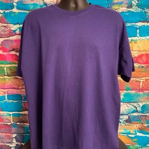 May include: A plain, solid purple t-shirt with short sleeves and a crew neck.
