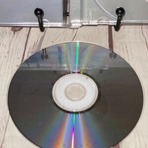 May include: A silver compact disc with a rainbow iridescent effect. The disc is blank and has a small central hole.