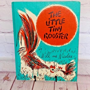 May include: A vintage children's book titled "The Little Tiny Rooster" with a teal cover. The cover features a red circle with the title in black, and illustrations of roosters in red, black, and white.