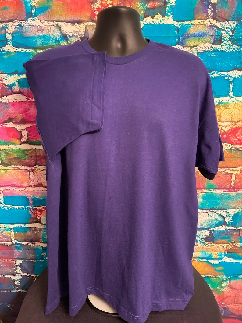 May include: A solid purple t-shirt with short sleeves and a crew neck.