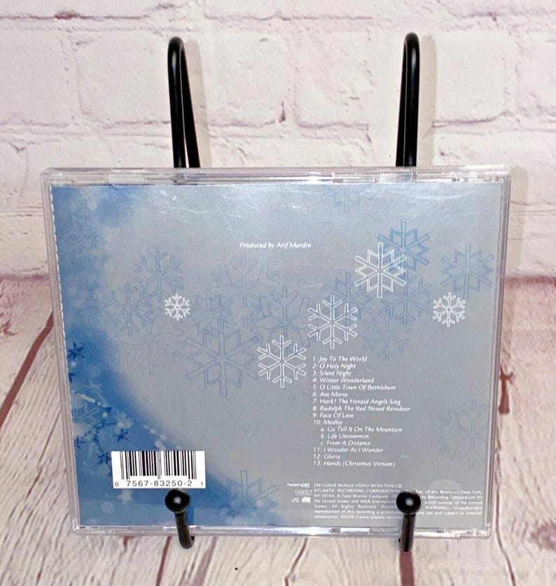 May include: A CD case with a blue and white snowflake design. The back of the case lists the songs on the CD, including "Joy to the World", "O Holy Night", and "Winter Wonderland".