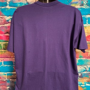 May include: A plain, solid purple short-sleeved t-shirt. The shirt is made of a soft, comfortable material.