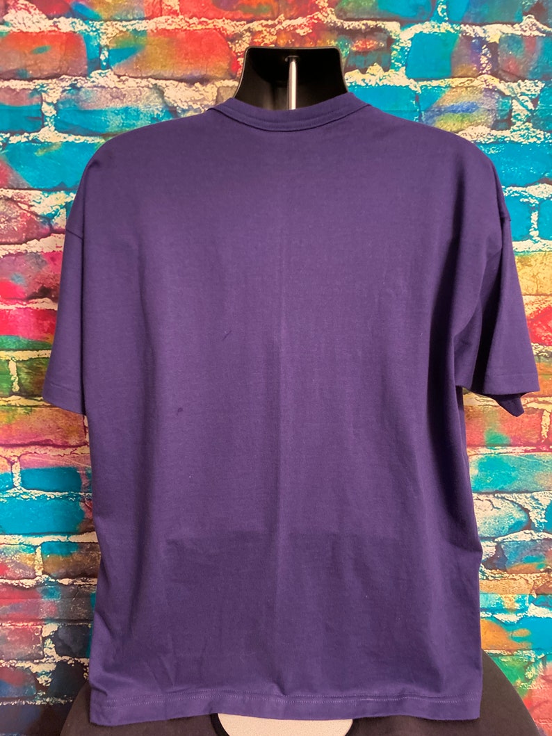 May include: A plain, solid purple short-sleeved t-shirt. The shirt is made of a soft, comfortable material.