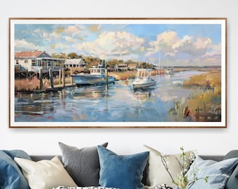 Op de afbeelding: Een schilderij van een waterkant met huizen op palen, boten die in het water liggen en een bewolkte lucht. Het schilderij is ingelijst in een licht houten lijst.