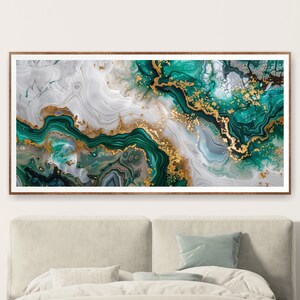 May include: Abstract art print featuring swirling green and gold patterns resembling marble or agate. The print is framed in a light brown wood frame.