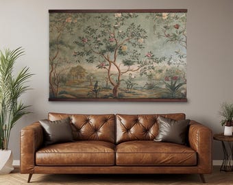 Puede incluir: Un tapiz rectangular grande con una escena de paisaje impresa con árboles, flores en flor y follaje en tonos verde, marrón y rosa apagados, asegurado entre dos barras horizontales de madera oscura en la parte superior e inferior.