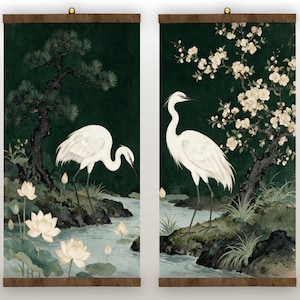 Pode incluir: Dois rolos de parede verticais com grous brancos numa paisagem verde-escura. O painel esquerdo mostra um grou perto de um riacho com flores de lótus e um pinheiro. O painel direito mostra um grou junto a uma cerejeira em flor.