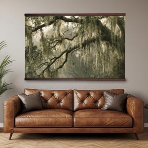 May include: A rectangular wall hanging featuring a landscape print of large, dark tree branches draped in long, light-colored Spanish moss. The print is secured between two horizontal dark wood slats at the top and bottom edges.