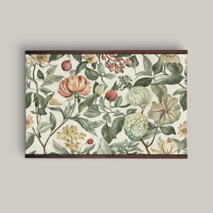 Vintage floral tapestry featuring detailed illustrations of various flowers and green leaves, printed on light canvas-textured fabric, with walnut-colored wooden hangers on top and bottom.
