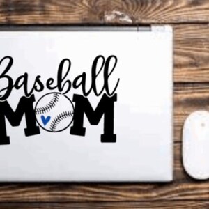 May include: A white laptop with a black vinyl sticker that says "Baseball Mom" with a baseball graphic.