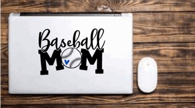 May include: A white laptop with a black vinyl sticker that says "Baseball Mom" with a baseball graphic.