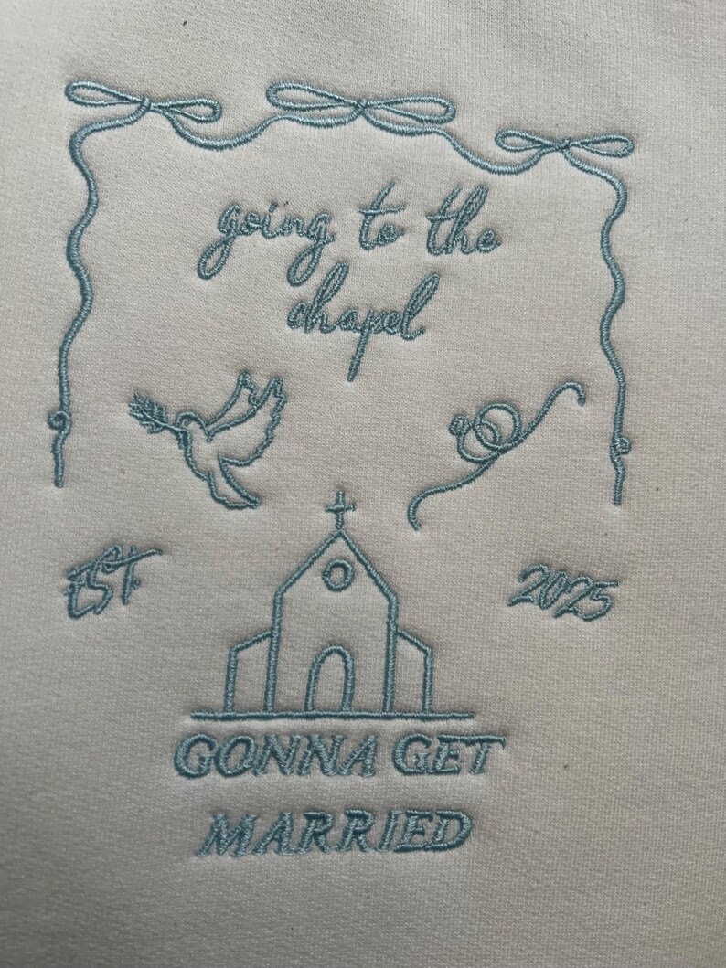 May include: A white sweatshirt with blue embroidery that says "going to the chapel est 2025 gonna get married" with a dove, a church, and a ring.