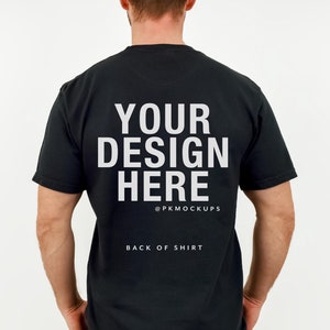 Könnte beinhalten: Ein schwarzes T-Shirt mit dem Text "YOUR DESIGN HERE" und "@PKMOCKUPS" auf der Rückseite. Der Text "BACK OF SHIRT" ist ebenfalls auf der Rückseite aufgedruckt.