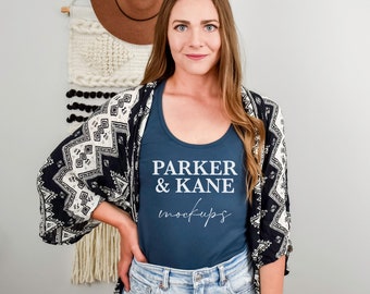 May include: A woman wearing a navy blue tank top with the text "PARKER & KANE mockups" printed on the front. She is wearing a black and white patterned kimono over the tank top and blue jeans.