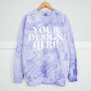 Może przedstawiać: Fioletowa bluza z nadrukiem tie-dye z napisem "YOUR DESIGN HERE" nadrukowanym na przodzie na biało.