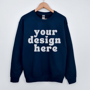 May include: A navy blue sweatshirt with the text "your design here" in white.