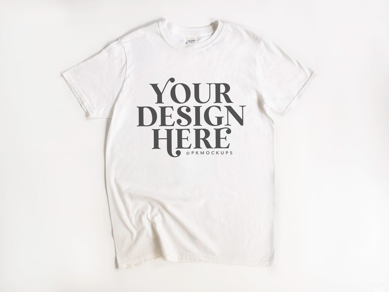 May include: White t-shirt with the text "YOUR DESIGN HERE" and the copyright symbol followed by "PKMOCKUPS".