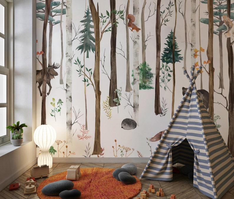May include: A wall mural featuring a watercolor forest scene with birch and pine trees, a moose, a squirrel, and a hedgehog. In the room, a blue and white striped teepee sits on a round orange rug, accompanied by wooden toys and a white lamp.