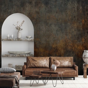 May include: A living room scene featuring a brown leather sofa, two wooden coffee tables, and a matching ottoman. The background is a textured wall with shades of brown and gray. Decorative items include vases and a pillow.