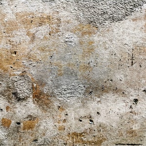 Puede incluir: Primer plano de una textura de pared desgastada. La superficie es una mezcla de gris claro y marr&oacute;n, con imperfecciones visibles y un acabado rugoso y desigual. Parches de tonos m&aacute;s oscuros a&ntilde;aden profundidad.