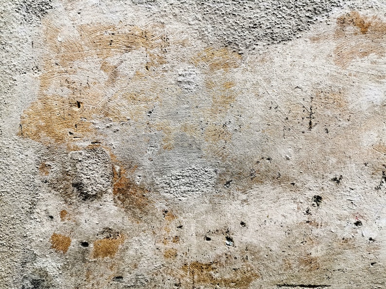 Puede incluir: Primer plano de una textura de pared desgastada. La superficie es una mezcla de gris claro y marr&oacute;n, con imperfecciones visibles y un acabado rugoso y desigual. Parches de tonos m&aacute;s oscuros a&ntilde;aden profundidad.