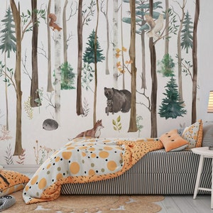 May include: A wall mural featuring a watercolor forest scene with birch and pine trees, a bear, a fox, a hedgehog, a squirrel, and an owl. The room includes a bed with a gray and white striped skirt, a patterned orange and gray quilt, and pillows.