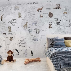 Puede incluir: Un mural de pared que muestra un mapa del mundo con ilustraciones de varios animales colocados en los continentes, incluyendo un panda, una jirafa y un elefante. El mapa incluye etiquetas de texto para oc&eacute;anos y pa&iacute;ses sobre un fondo gris claro.