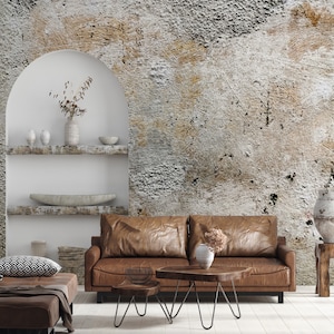 Puede incluir: Un sal&oacute;n con un sof&aacute; de cuero marr&oacute;n, mesas de centro de madera y una pared texturizada. Jarrones decorativos y un banco con un coj&iacute;n estampado se suman a la est&eacute;tica de la habitaci&oacute;n. La habitaci&oacute;n tiene una paleta de colores neutros.